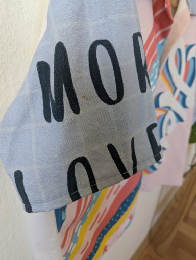 Ärmelansicht der Retro Bluse mit buntem Regenbogen und "Hey" Schriftzug