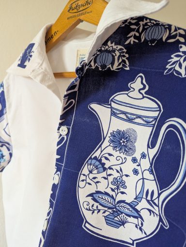 Bluse "Tea Time" in weiß und blau. Fokus auf Vorderteil mit großer Porzellankanne